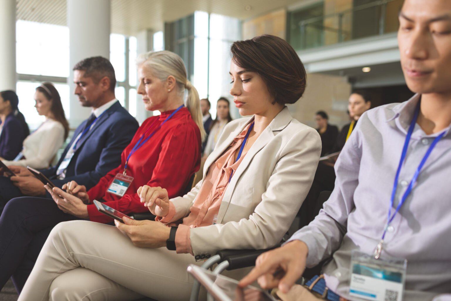 Strukovni fizioterapeut side view of diverse business people using digital tablet during business seminar in modern office building